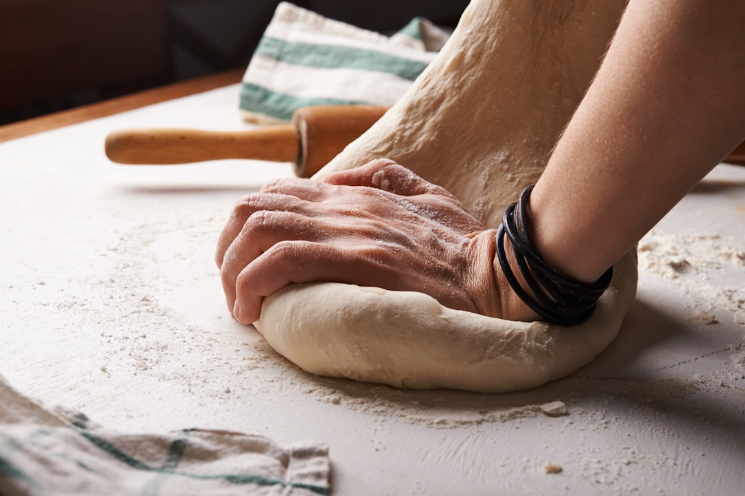 person kneading dough happily